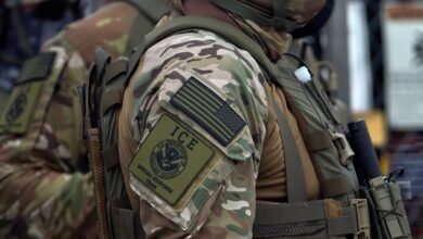 Close-up of an ICE Special Response Team member's tactical gear, showing patches.