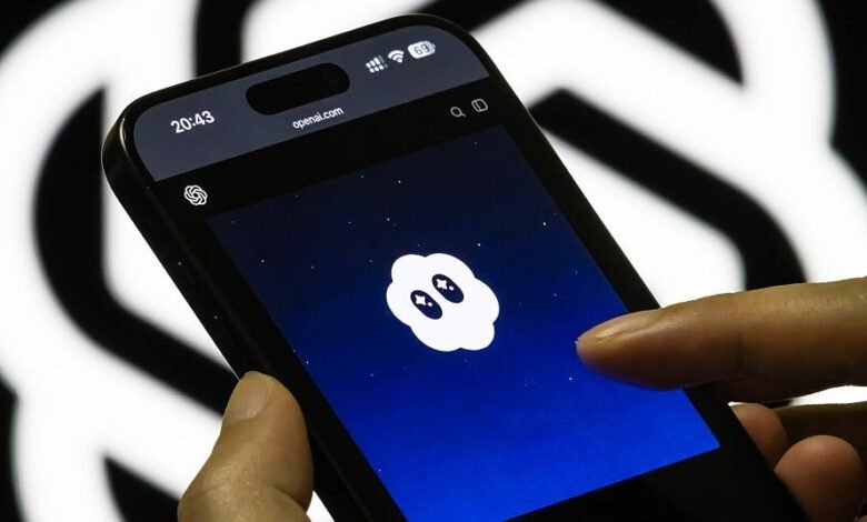A hand holds a smartphone displaying the OpenAI logo on a dark blue background with stars.