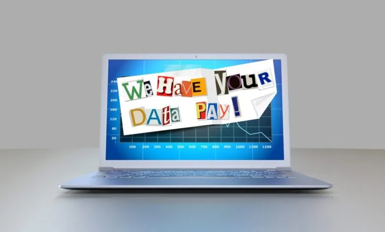 Laptop screen displaying ransom demand with cut-out letters: 'We Have Your Data PAY!'