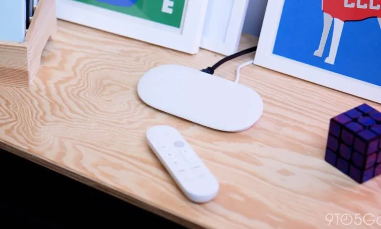 White Google TV remote and streaming device on a wooden surface