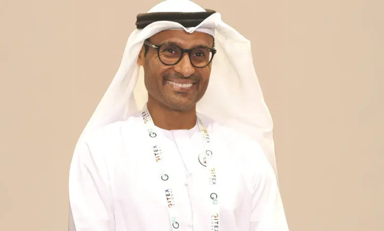Portrait of H.E. Dr. Mohamed Al Kuwaiti wearing traditional Emirati attire and glasses.
