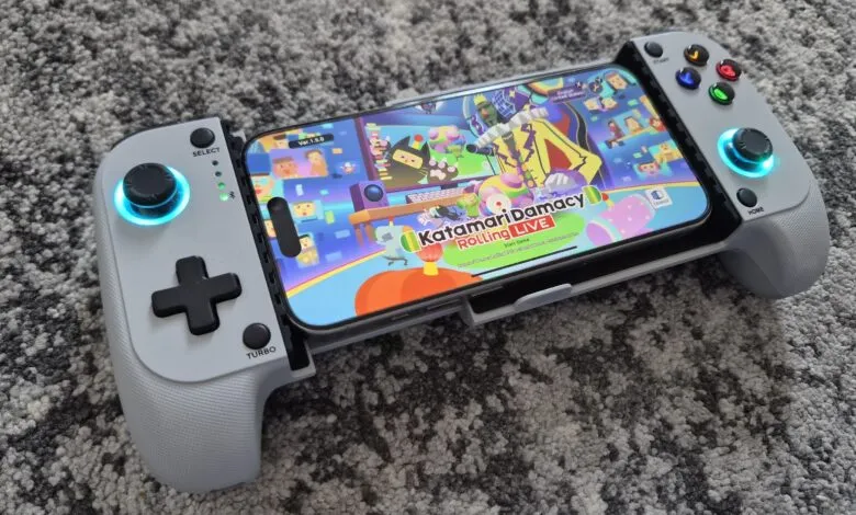 iPhone displaying Katamari Damacy Rolling Live game with a controller attached.