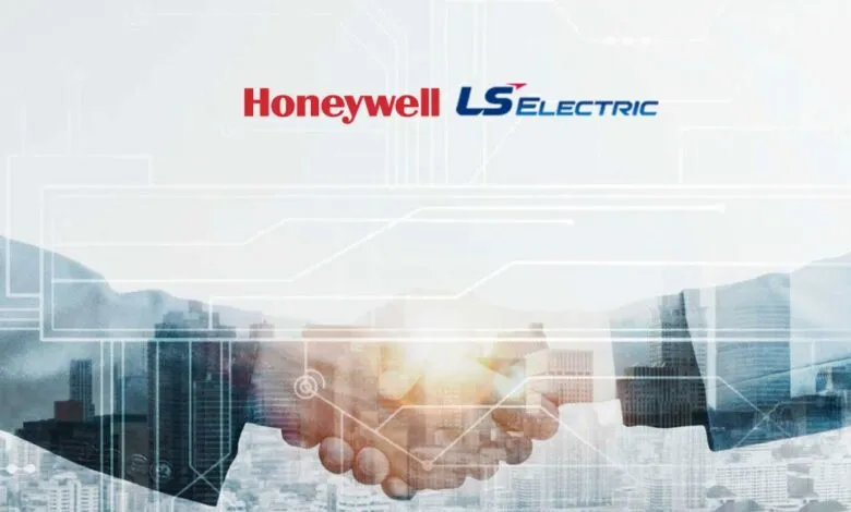 Two business people shaking hands over a city skyline with Honeywell and LS ELECTRIC logos.