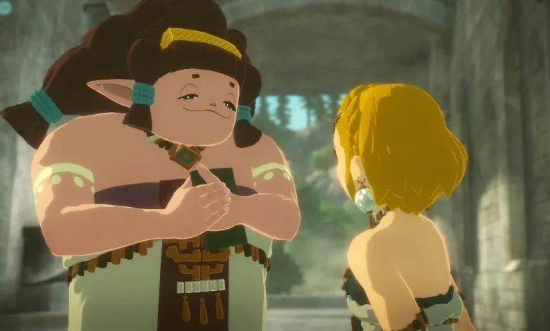 A large woman with dark hair and a friendly expression talks to a woman with blonde hair.