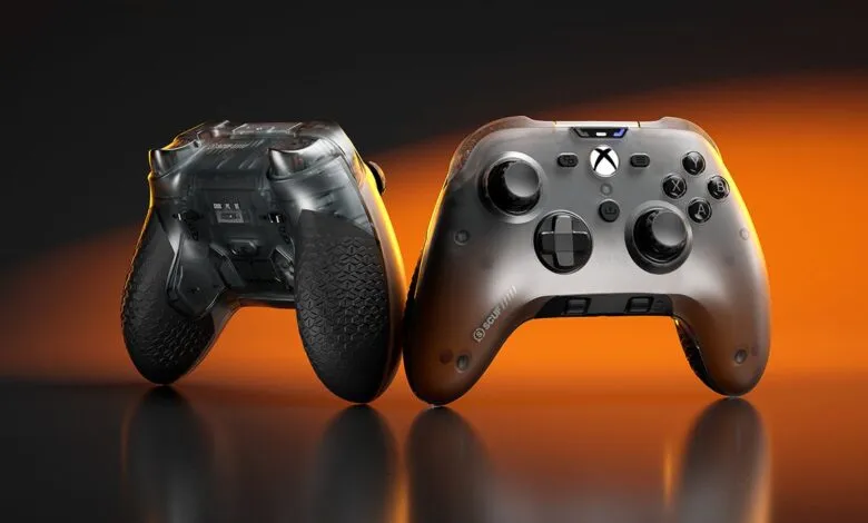Two transparent Xbox controllers with black textured grips and orange lighting.