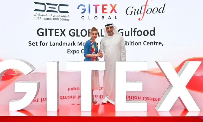 Man and woman shaking hands in front of GITEX GLOBAL and Gulfood logos.