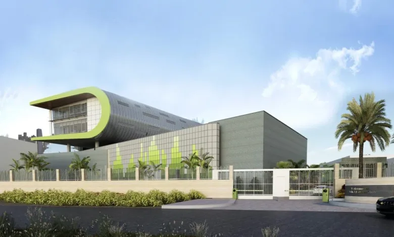 Modern architectural building with a curved green roof and glass facade.