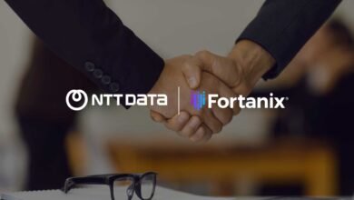 Two business professionals shaking hands with NTT DATA and Fortanix logos overlaid.