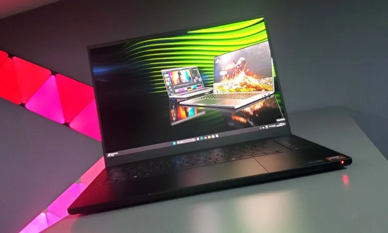 A sleek black laptop displaying video editing software and a game, with ambient lighting.