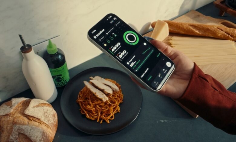 Person holding a smartphone displaying a nutrition tracking app next to a meal.