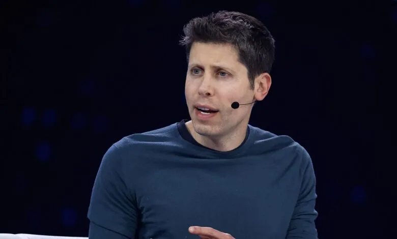 Sam Altman, CEO of OpenAI, speaks on stage with a microphone attached to his shirt.