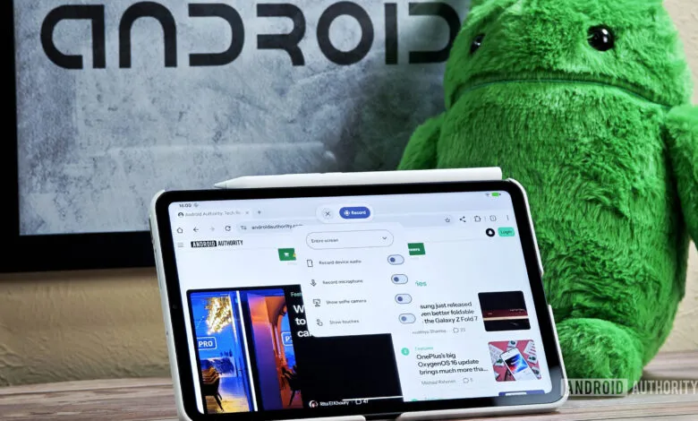 Android tablet displaying a screen recording interface with a stylus and a green Android mascot plush toy.