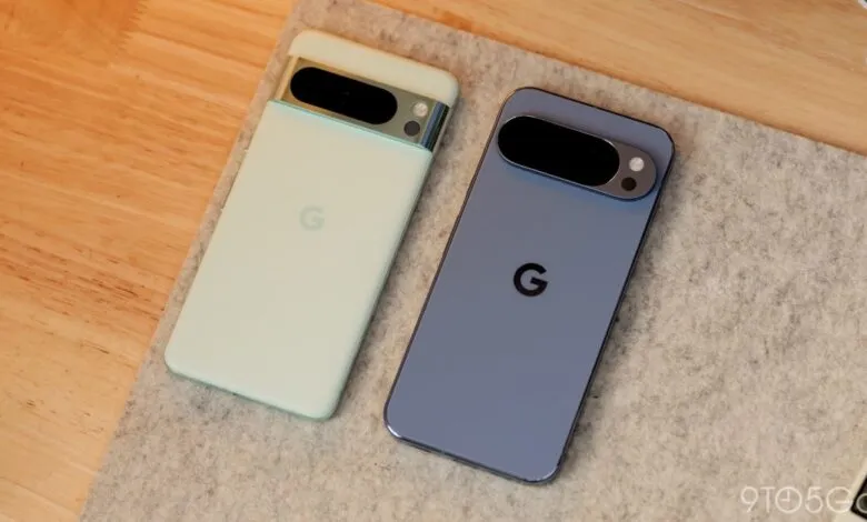 Two Google Pixel phones, one light green and one blue, lie on a grey felt surface next to a wooden desk.