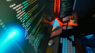 Close-up of computer screen displaying lines of code with a blue light flare.