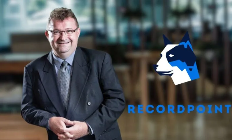 Man in suit smiling with Recordpoint logo and text
