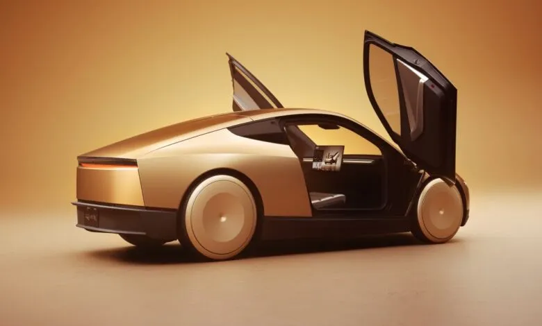 Futuristic gold concept car with butterfly doors open, showing interior screen.