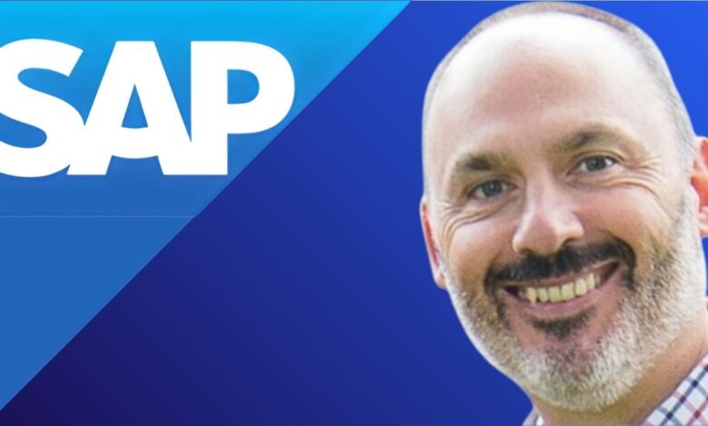 Close-up of a smiling man with a beard next to the SAP logo.