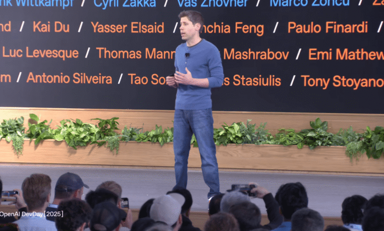 Man in blue shirt and jeans speaking on stage at OpenAI DevDay 2025.
