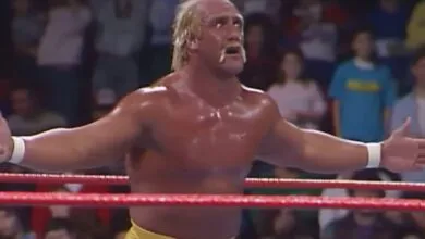 Hulk Hogan in a wrestling ring with arms outstretched, audience in background.