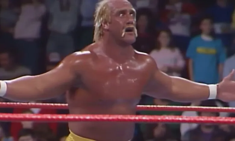 Hulk Hogan in a wrestling ring with arms outstretched, audience in background.