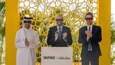 Three men in 3D glasses clap at a podium with Snapchat logo