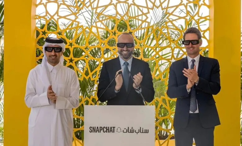 Three men in 3D glasses clap at a podium with Snapchat logo