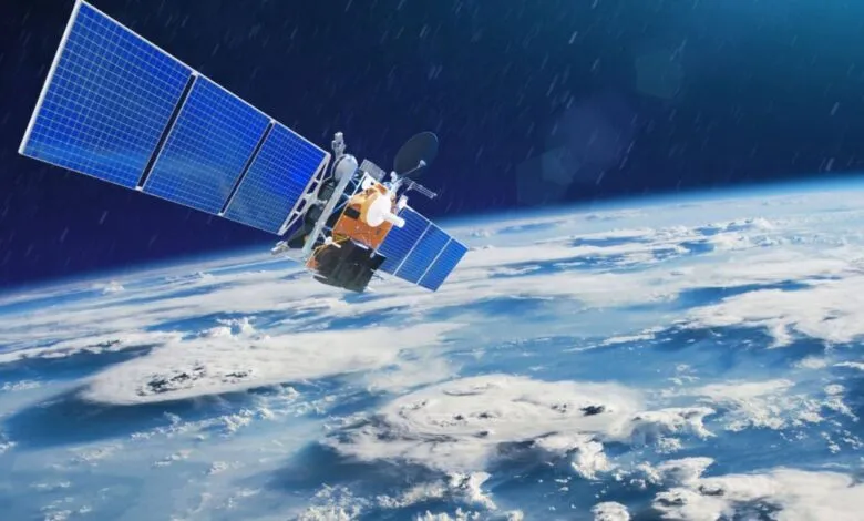 A satellite with solar panels orbits Earth, showing clouds and atmosphere.