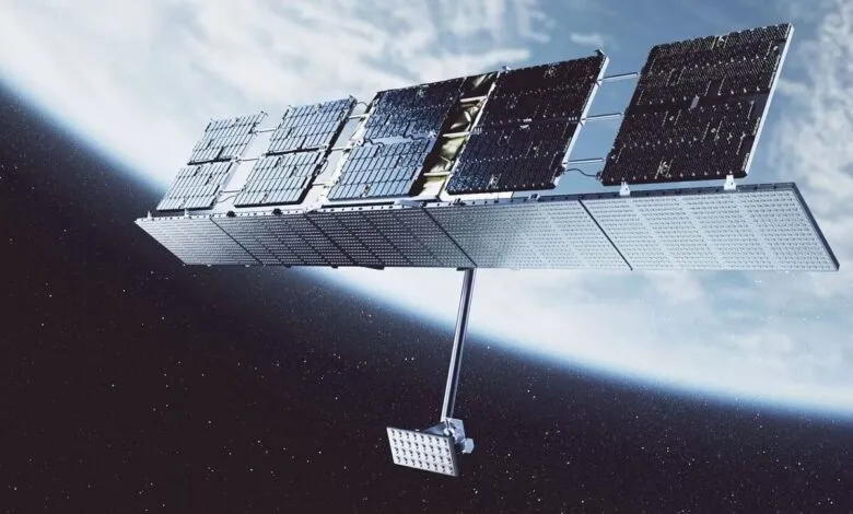 A satellite with large solar panels orbits Earth against a starry sky.