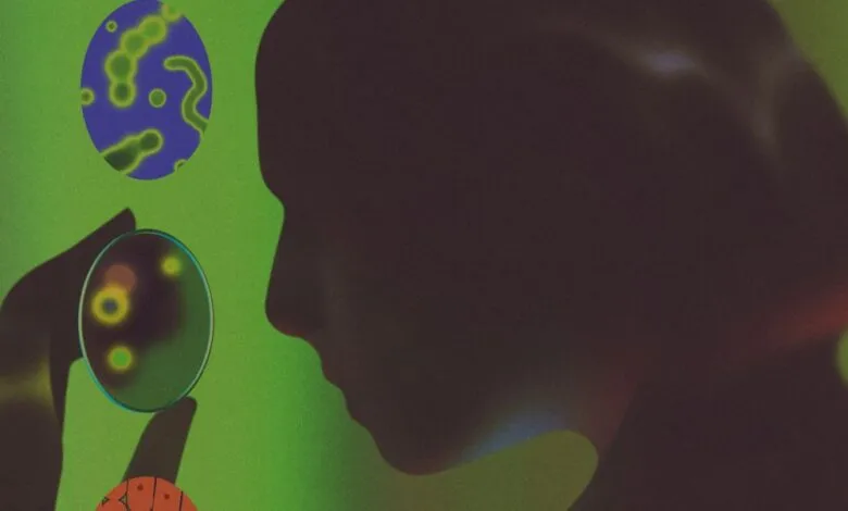 Silhouette of a person examining a petri dish with glowing microorganisms.