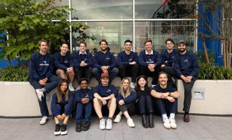 A diverse team of young professionals in navy blue sweatshirts with the Starbridge logo.