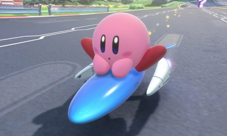 Kirby riding a blue rocket-like vehicle on a race track.