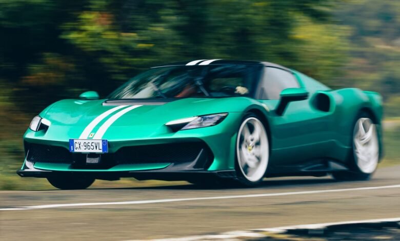 A green Ferrari 296 GTB with white racing stripes drives on a road.