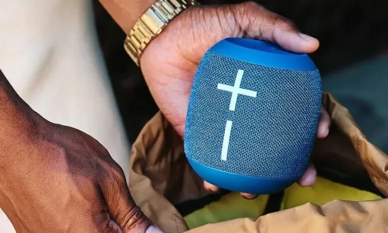 Person holding a blue Ultimate Ears Wonderboom 4 portable speaker.