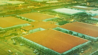 Aerial view of a large industrial complex with orange-tiled roofs and green surrounding areas.