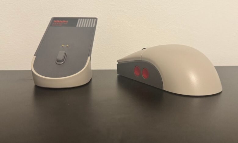 A retro-style computer mouse and its charging dock, inspired by the NES controller.