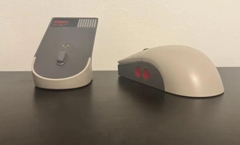 A retro-style computer mouse and its charging dock, inspired by the NES controller.