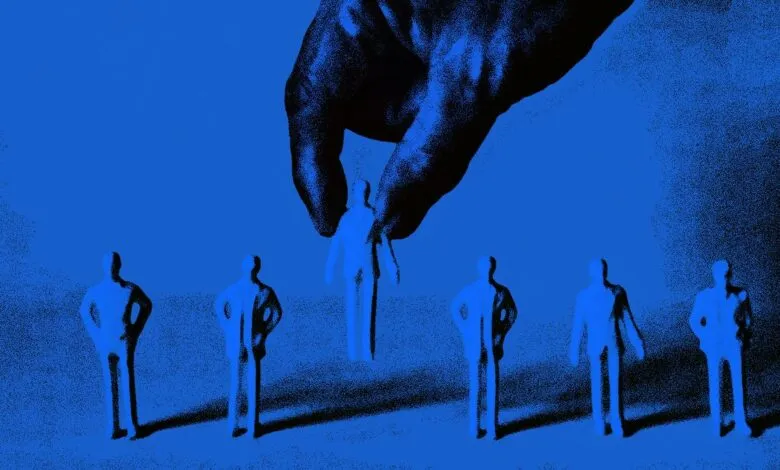 A large hand picks up a small blue figurine of a person from a line of identical figurines.
