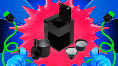 Black coffee maker with green cords and blue thumbs-up hands against a vibrant background.