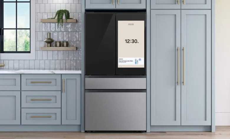 Modern kitchen with a smart refrigerator displaying the time and a water filter ad.