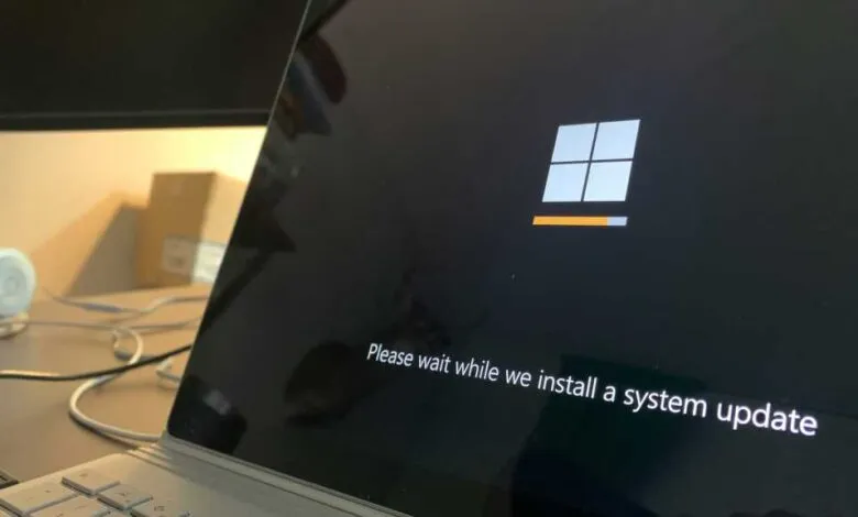 Laptop screen displaying Windows 11 system update progress bar.