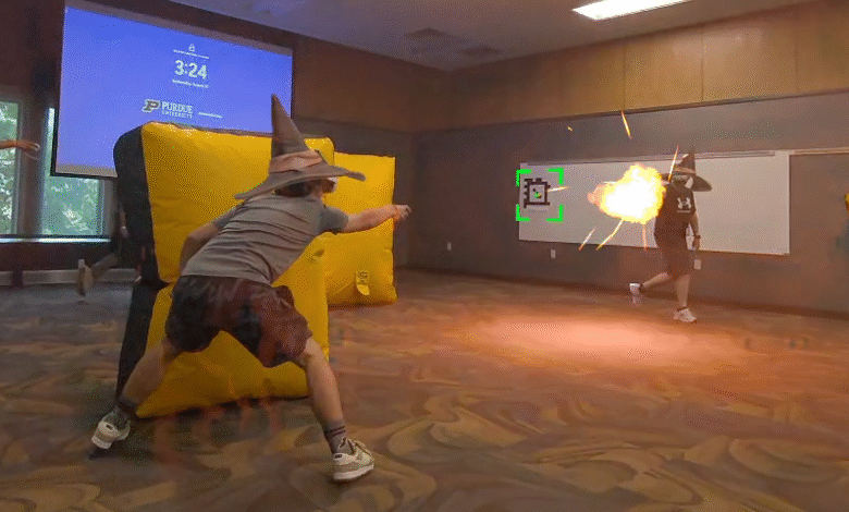 Person in wizard hat aiming a projectile at another person in a room with a projector screen.