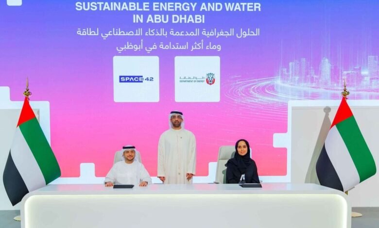 Three individuals in formal attire stand behind a desk with UAE flags, in front of a screen displaying 'Geospatial and AI Solutions for Sustainable Energy and Water in Abu Dhabi'.