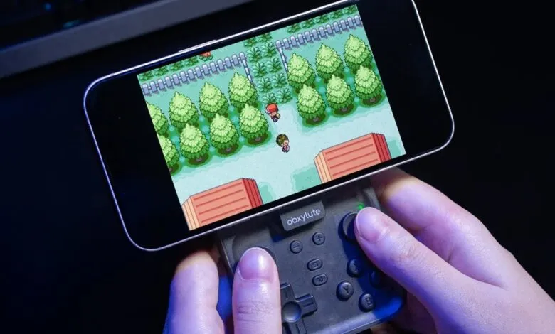 Person playing a retro Pokemon game on a smartphone with a controller attachment.