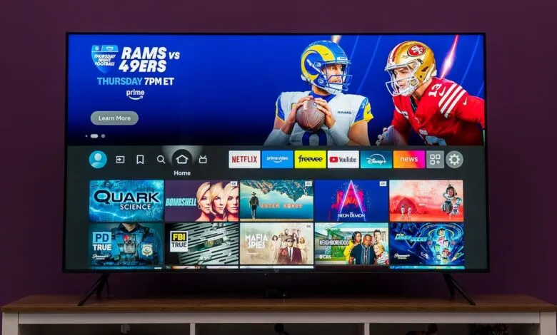 A modern smart TV displaying the Amazon Fire TV interface with NFL game and streaming app icons.