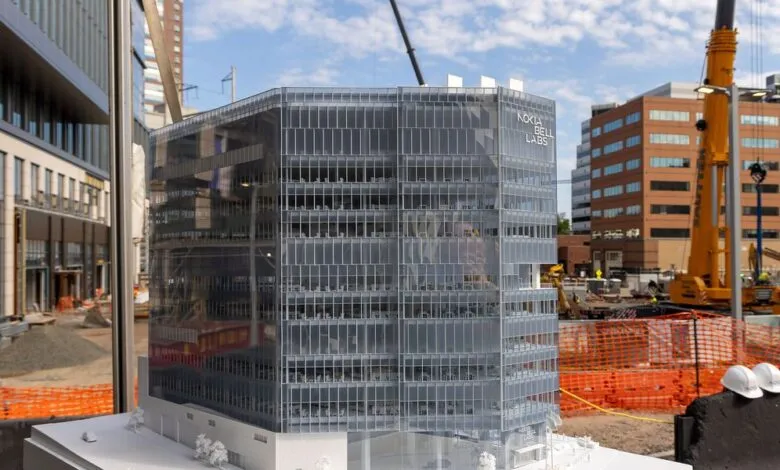 Architectural model of Nokia Bell Labs headquarters with construction site in background.
