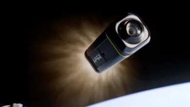 A black and yellow Apex camera floats in space with Earth visible below.