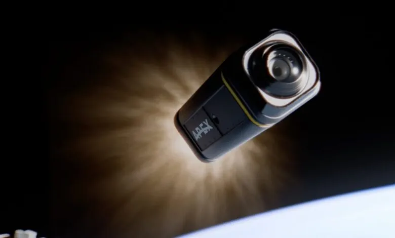 A black and yellow Apex camera floats in space with Earth visible below.