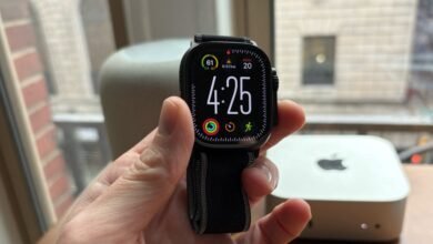 Close-up of an Apple Watch Ultra with a black band displaying the time and activity rings.