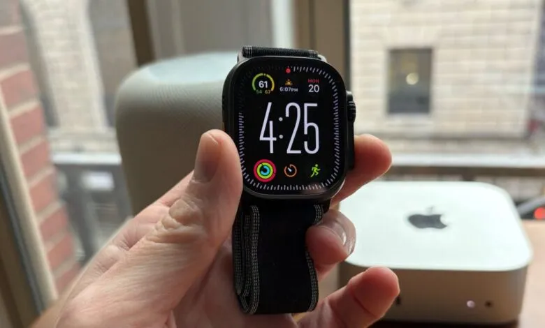 Close-up of an Apple Watch Ultra with a black band displaying the time and activity rings.