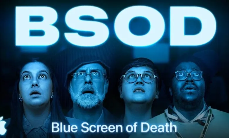 Four people looking up in shock at a large blue screen displaying 'BSOD'